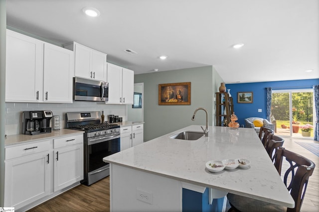 224 Anna Gray Cir, Easley, SC 29640 - kitchen featuring stainless steel appliances, a sink, an island with sink, tasteful backsplash, and dark wood finished floors