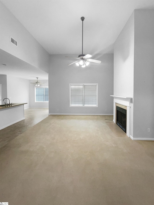 134 Lauren Wood Cir, Taylors, SC 29687 - unfurnished living room with a ceiling fan, light colored carpet, a fireplace, baseboards, and a sink