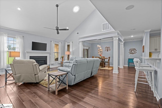 79 Modesto Ln, Simpsonville, SC 29681 - living area with a glass covered fireplace, dark wood-type flooring, ornate columns, high vaulted ceiling, and crown molding