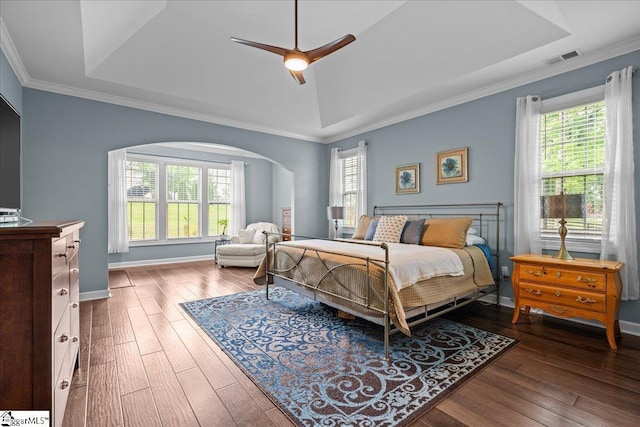 79 Modesto Ln, Simpsonville, SC 29681 - bedroom featuring multiple windows, arched walkways, dark wood-type flooring, crown molding, and a tray ceiling