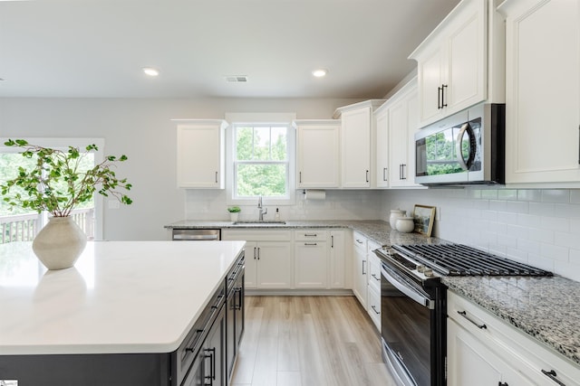 738 Judah Dr, Moore, SC 29369 - kitchen with stainless steel appliances, white cabinets, tasteful backsplash, recessed lighting, and light stone counters