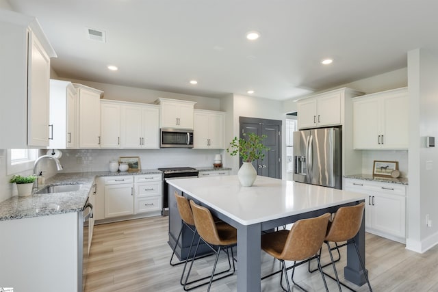738 Judah Dr, Moore, SC 29369 - kitchen with stainless steel appliances, a kitchen breakfast bar, tasteful backsplash, a center island, and white cabinetry