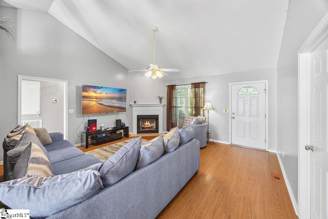 353 Old John Dodd Rd, Boiling Springs, SC 29316 - living room featuring a ceiling fan, a lit fireplace, light wood-type flooring, and high vaulted ceiling
