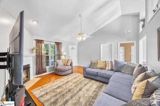 353 Old John Dodd Rd, Boiling Springs, SC 29316 - living area featuring a ceiling fan, wood finished floors, a warm lit fireplace, and high vaulted ceiling