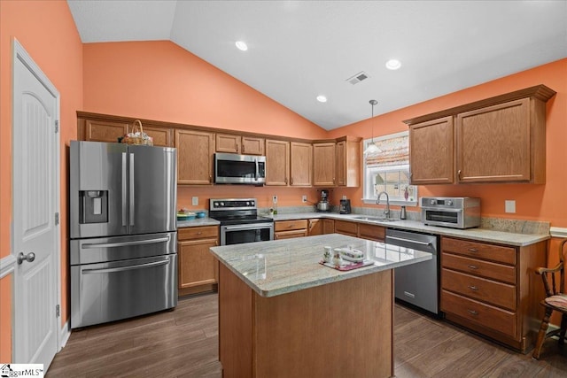 636 Cordelia Ct, Boiling Springs, SC 29316 - kitchen with appliances with stainless steel finishes, vaulted ceiling, dark wood finished floors, brown cabinets, and pendant lighting