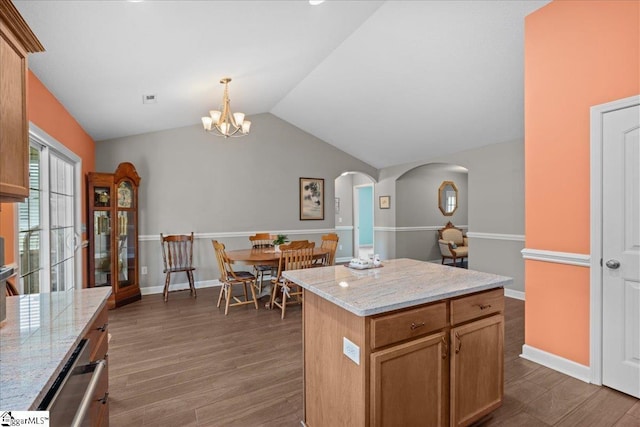 636 Cordelia Ct, Boiling Springs, SC 29316 - kitchen with arched walkways, a chandelier, dark wood-style floors, lofted ceiling, and a kitchen island