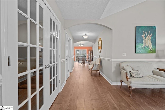 636 Cordelia Ct, Boiling Springs, SC 29316 - hall featuring french doors, arched walkways, a textured ceiling, and wood finished floors