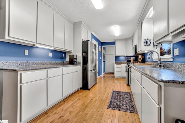 203 Ponder Rd, Greer, SC 29651 - kitchen with stainless steel appliances, white cabinetry, a textured ceiling, light wood finished floors, and dark stone countertops