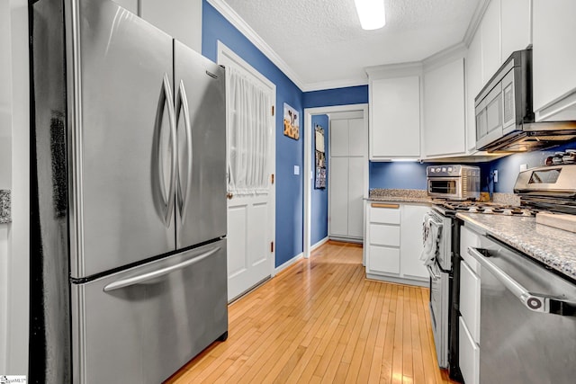 203 Ponder Rd, Greer, SC 29651 - kitchen featuring appliances with stainless steel finishes, a textured ceiling, ornamental molding, white cabinets, and light wood-type flooring