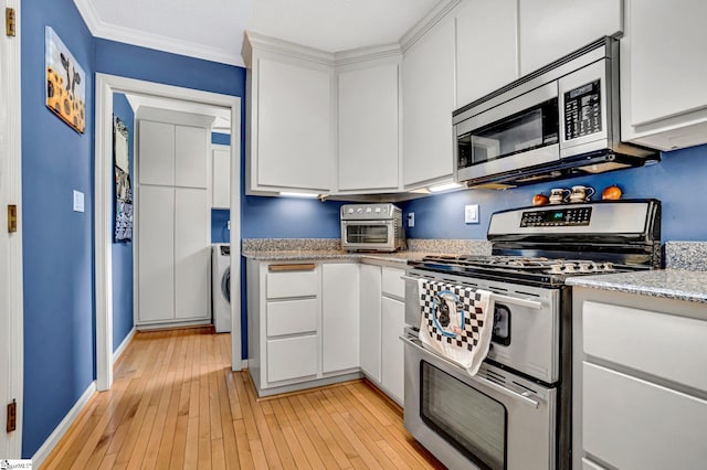 203 Ponder Rd, Greer, SC 29651 - kitchen with appliances with stainless steel finishes, light wood-style floors, white cabinets, washer / dryer, and crown molding