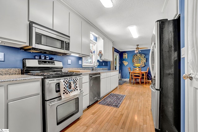 203 Ponder Rd, Greer, SC 29651 - kitchen featuring appliances with stainless steel finishes, light wood finished floors, white cabinets, a textured ceiling, and ceiling fan