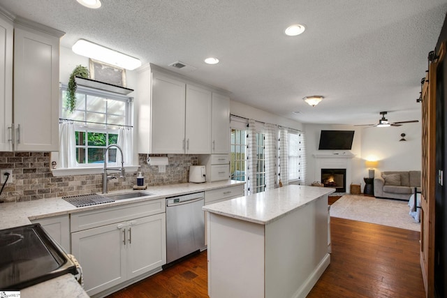 101 Bitternut Ln, Taylors, SC 29687 - kitchen with dishwasher, a textured ceiling, a warm lit fireplace, a kitchen island, and tasteful backsplash
