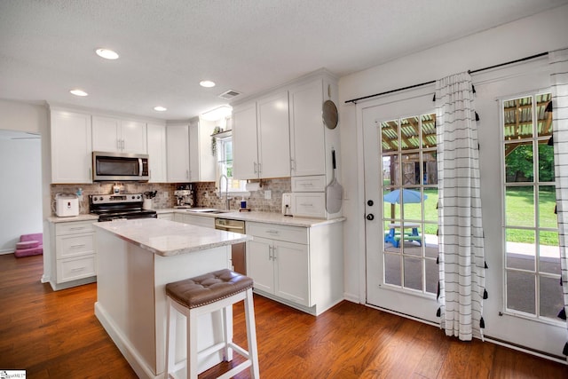 101 Bitternut Ln, Taylors, SC 29687 - kitchen with appliances with stainless steel finishes, dark wood-type flooring, white cabinetry, and recessed lighting