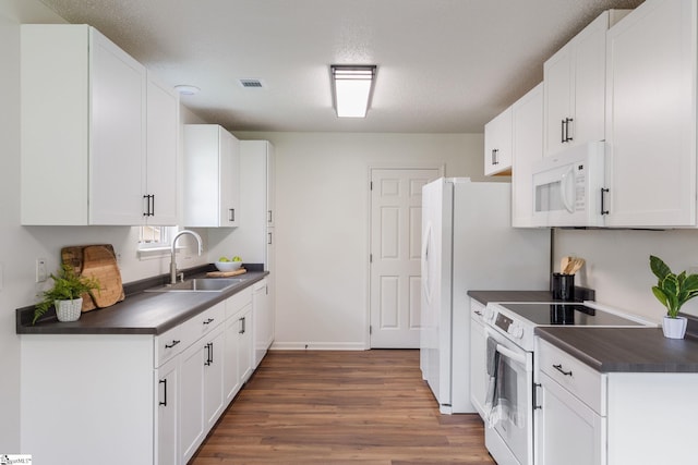 310 W Bushy Hill Dr, Duncan, SC 29334 - kitchen with white appliances, dark countertops, wood finished floors, and white cabinets