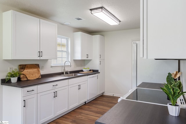 310 W Bushy Hill Dr, Duncan, SC 29334 - kitchen with white dishwasher, dark countertops, dark wood-type flooring, white cabinets, and a textured ceiling