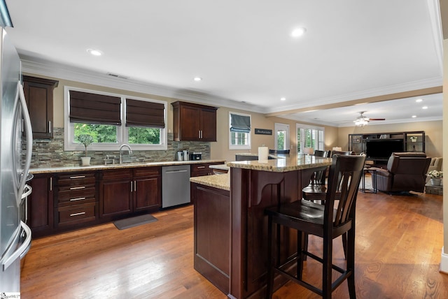 103 Crestview Cir, Greer, SC 29651 - kitchen featuring stainless steel appliances, a kitchen bar, a center island, backsplash, and wood finished floors