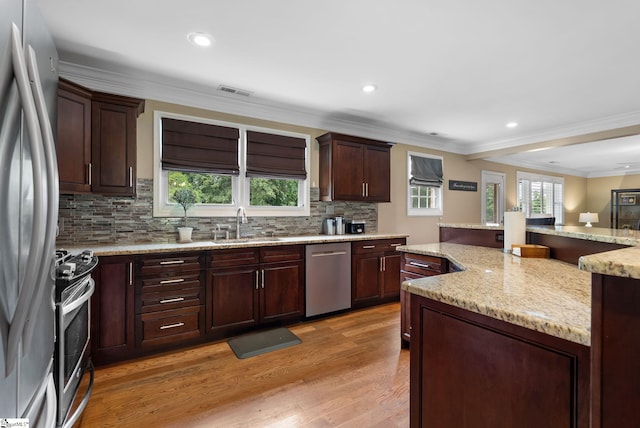 103 Crestview Cir, Greer, SC 29651 - kitchen with stainless steel appliances, decorative backsplash, light wood-style flooring, crown molding, and light stone countertops