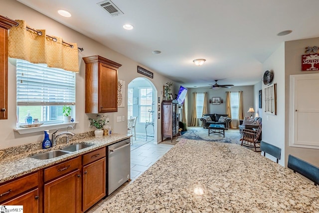 208 Castleton Cir, Boiling Springs, SC 29316 - kitchen with stainless steel dishwasher, arched walkways, brown cabinetry, light stone countertops, and ceiling fan