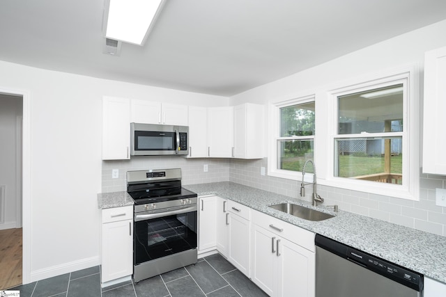 661 Maple Dr, Greer, SC 29651 - kitchen featuring stainless steel appliances, white cabinetry, light stone counters, and decorative backsplash