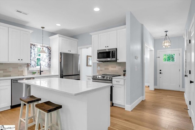 11 Echo Dr, Travelers Rest, SC 29690 - kitchen with appliances with stainless steel finishes, tasteful backsplash, a center island, light countertops, and white cabinets