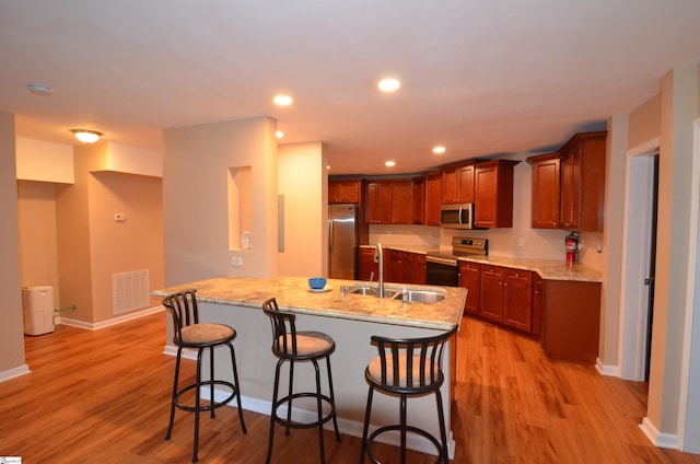 108 Dillard Creek Ct, Greer, SC 29651 - kitchen featuring stainless steel appliances, a kitchen breakfast bar, light wood finished floors, light stone counters, and recessed lighting