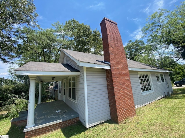 719 Chestnut St, Laurens, SC 29360 - view of home's exterior with a chimney and a lawn