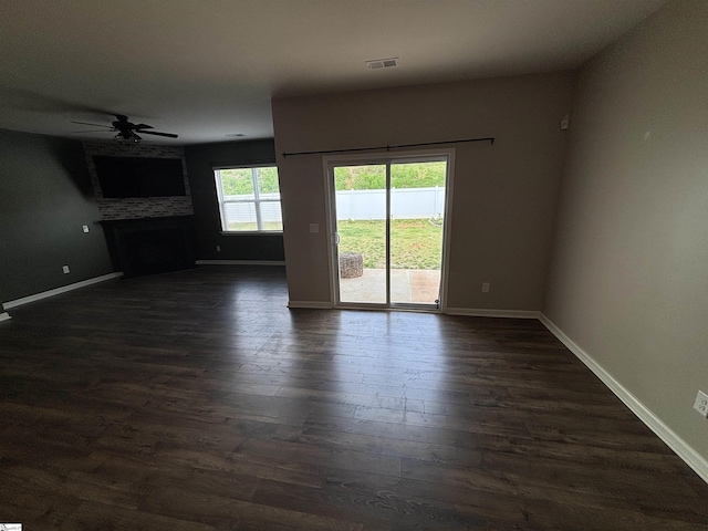 63 Oak Edge Ln, Greer, SC 29651 - unfurnished living room featuring a fireplace, ceiling fan, and dark wood-style flooring