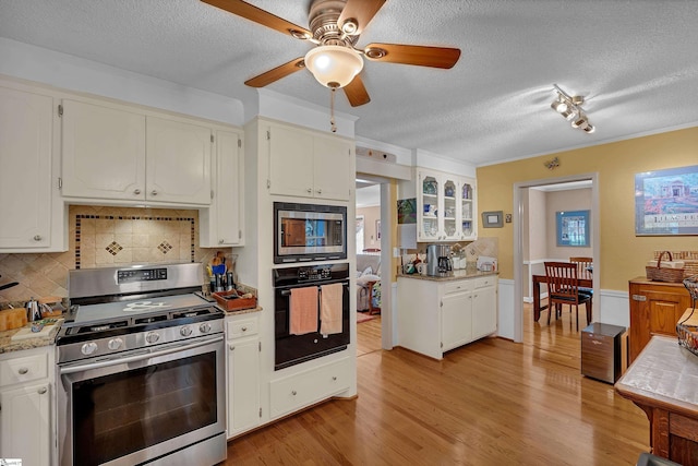135 James Ave, Wellford, SC 29385 - kitchen with stainless steel appliances, a textured ceiling, decorative backsplash, a ceiling fan, and light wood-style flooring
