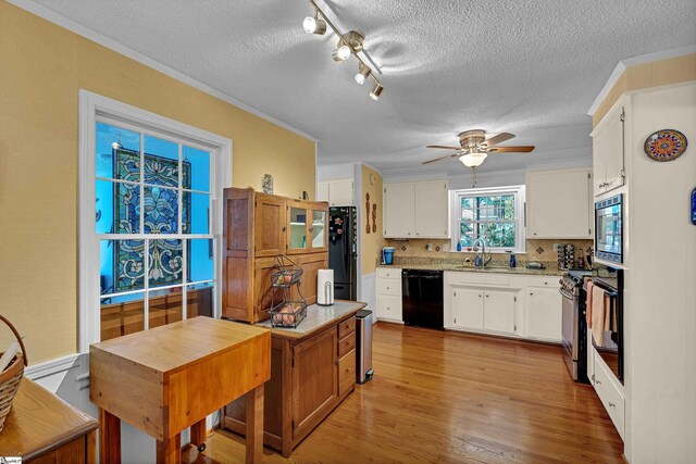 135 James Ave, Wellford, SC 29385 - kitchen with black appliances, a textured ceiling, a ceiling fan, white cabinets, and light wood finished floors