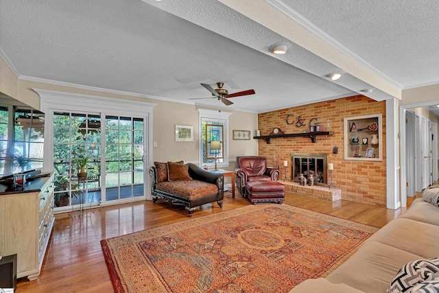 135 James Ave, Wellford, SC 29385 - living area featuring a textured ceiling, wood finished floors, ornamental molding, ceiling fan, and a fireplace