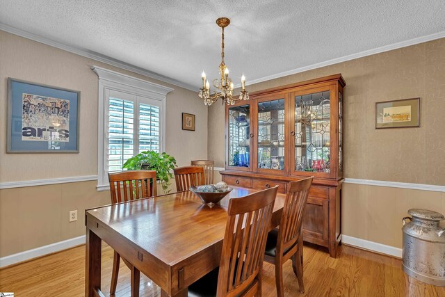 135 James Ave, Wellford, SC 29385 - dining room featuring a chandelier, light wood-style flooring, a textured ceiling, and ornamental molding