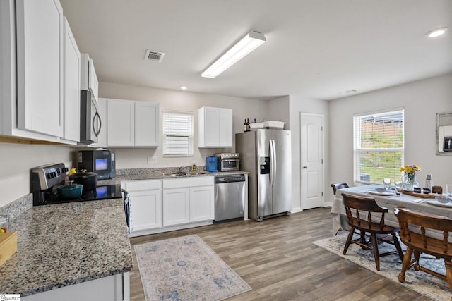 314 Long Grove Ln, Greer, SC 29650 - kitchen with stainless steel appliances, white cabinets, light wood-style flooring, light stone countertops, and recessed lighting
