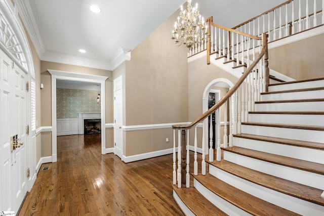 15 Annas Pl, Simpsonville, SC 29681 - entryway featuring ornamental molding, stairs, a fireplace, wood finished floors, and a chandelier