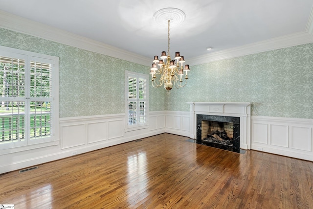 15 Annas Pl, Simpsonville, SC 29681 - unfurnished living room featuring a chandelier, a wainscoted wall, a high end fireplace, ornamental molding, and wood finished floors