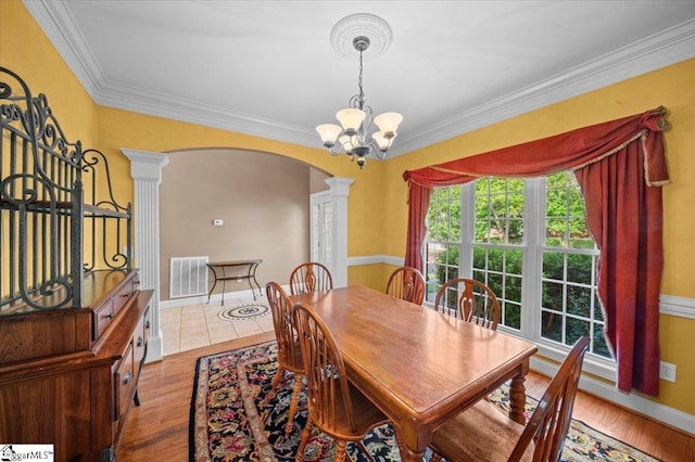118 Glencreek Dr, Greer, SC 29650 - dining space with ornate columns, arched walkways, a chandelier, ornamental molding, and wood finished floors