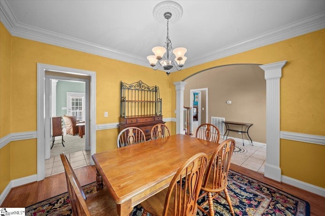 118 Glencreek Dr, Greer, SC 29650 - dining room featuring ornate columns, arched walkways, a chandelier, ornamental molding, and wood finished floors