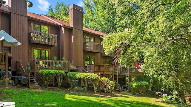 2 Creekside Way, Greenville, SC 29609 - rear view of house featuring a chimney, a balcony, a lawn, and a wooden deck