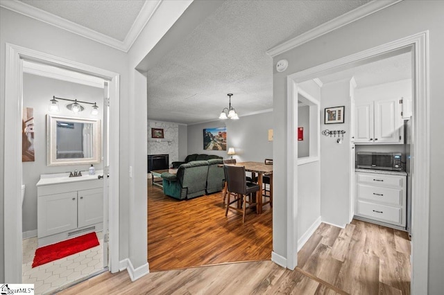 2 Creekside Way, Greenville, SC 29609 - corridor featuring light wood finished floors, a chandelier, a textured ceiling, and crown molding