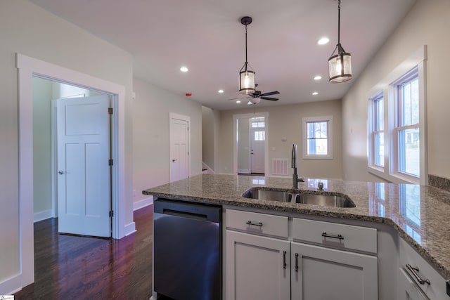 913 Dunbar St, Greenville, SC 29601 - kitchen with stainless steel dishwasher, dark wood finished floors, a peninsula, white cabinetry, and decorative light fixtures