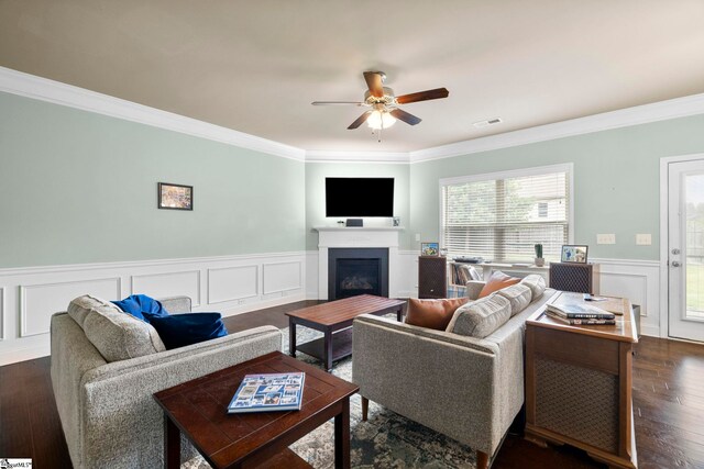 415 Bridge Crossing Dr, Simpsonville, SC 29681 - living room with crown molding, a ceiling fan, a wainscoted wall, a fireplace, and dark wood finished floors
