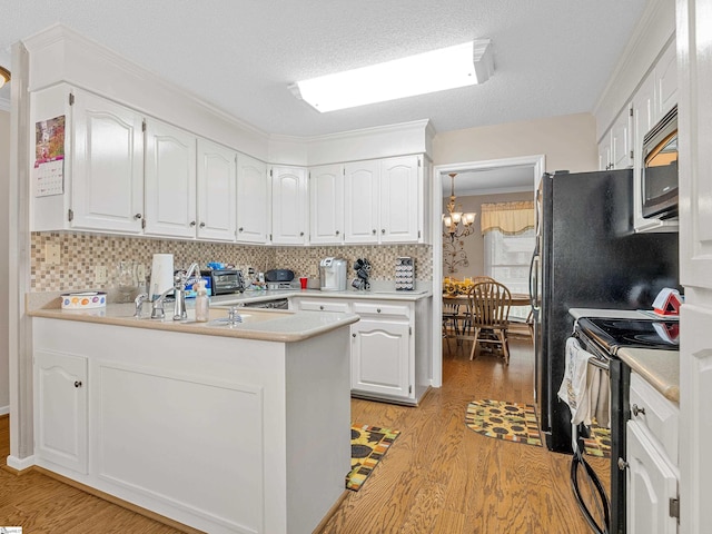 209 Thornhill Dr, Spartanburg, SC 29301 - kitchen featuring appliances with stainless steel finishes, light wood-style flooring, white cabinets, and tasteful backsplash