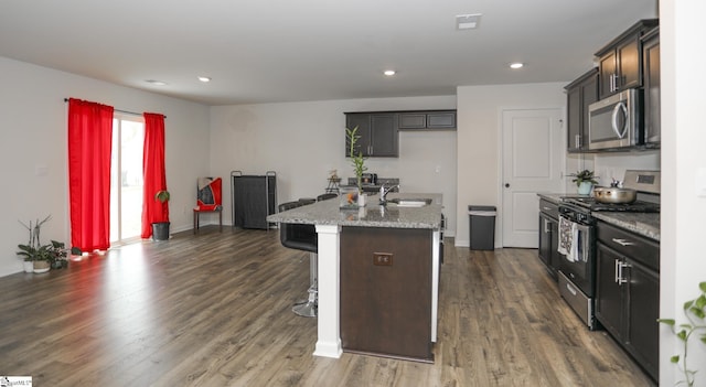 1421 Trotting Ave, Roebuck, SC 29376 - kitchen with stainless steel appliances, dark wood-style flooring, a kitchen island with sink, recessed lighting, and light stone counters