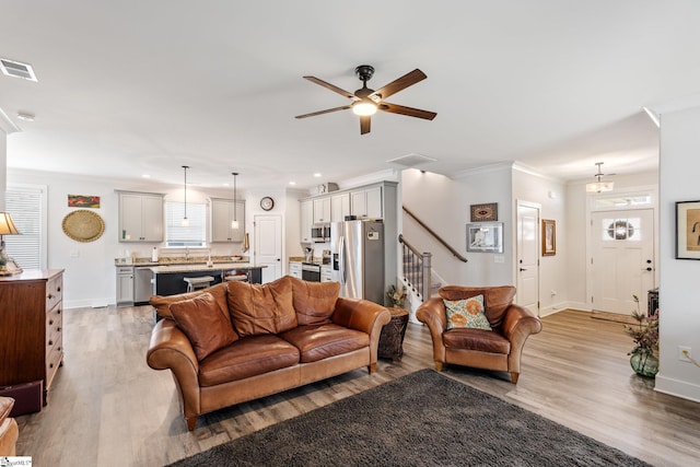 27 Mossycup Rd, Taylors, SC 29687 - living room with stairs, light wood finished floors, a ceiling fan, crown molding, and recessed lighting
