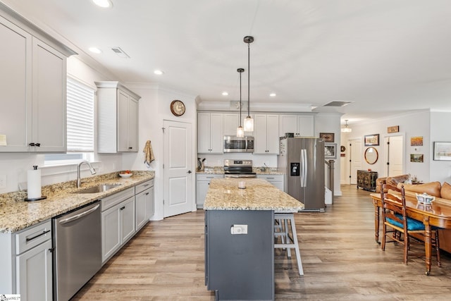 27 Mossycup Rd, Taylors, SC 29687 - kitchen with stainless steel appliances, ornamental molding, a center island, a breakfast bar, and light wood finished floors