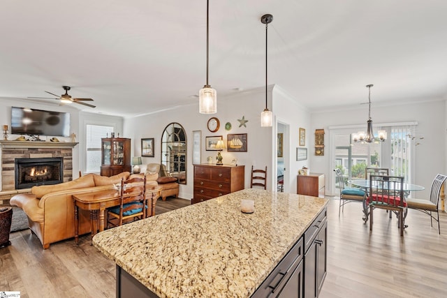 27 Mossycup Rd, Taylors, SC 29687 - kitchen featuring a fireplace, a ceiling fan, ornamental molding, healthy amount of natural light, and light wood-type flooring