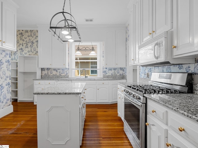 772 Glendalyn Ave, Spartanburg, SC 29302 - kitchen featuring stainless steel gas range, white microwave, hardwood / wood-style floors, white cabinetry, and wallpapered walls