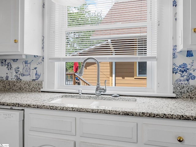 772 Glendalyn Ave, Spartanburg, SC 29302 - detailed view of white dishwasher, white cabinetry, and light stone countertops