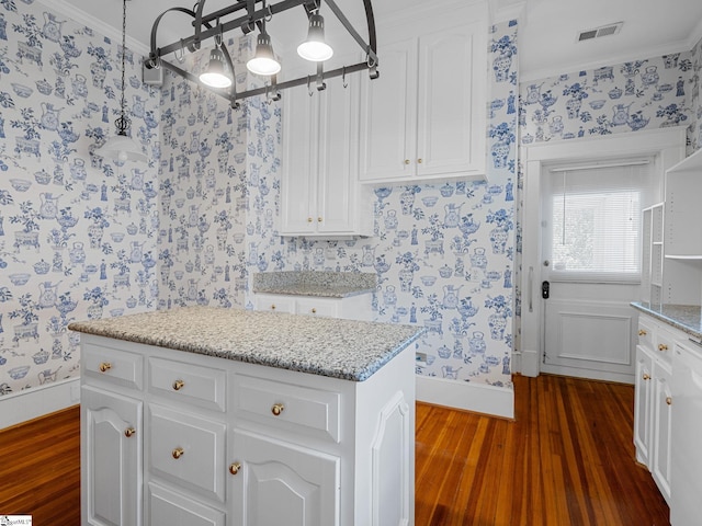 772 Glendalyn Ave, Spartanburg, SC 29302 - kitchen with wallpapered walls, dark wood-style flooring, crown molding, white cabinetry, and light stone countertops