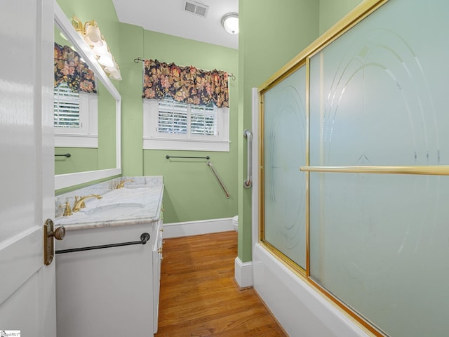 772 Glendalyn Ave, Spartanburg, SC 29302 - full bath with double vanity, wood finished floors, and enclosed tub / shower combo