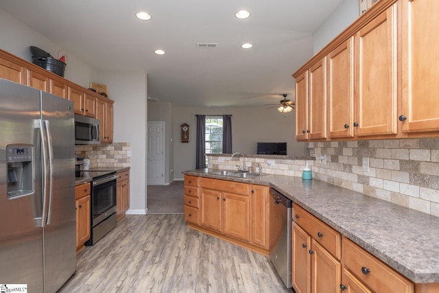 112 Pendock Ln, Piedmont, SC 29673 - kitchen featuring appliances with stainless steel finishes, a peninsula, decorative backsplash, light wood-type flooring, and recessed lighting